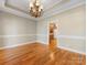 Dining room featuring hardwood floors, crown molding, chandelier, and view into kitchen at 153 Stafford Estates Dr, Salisbury, NC 28146