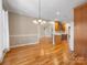Open dining room features hardwood floors, a chandelier, and view into kitchen and living room at 153 Stafford Estates Dr, Salisbury, NC 28146