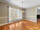 Dining room features hardwood floors, a chandelier, and three large windows with white curtains at 153 Stafford Estates Dr, Salisbury, NC 28146