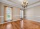 Dining room featuring hardwood floors, ample natural light, chandelier, and detailed trim work at 153 Stafford Estates Dr, Salisbury, NC 28146