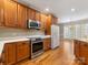 This kitchen has wood cabinets, stainless steel appliances, and a view into the dining room at 153 Stafford Estates Dr, Salisbury, NC 28146