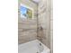 This bathroom features modern gray tile in the shower and a window with a view of a tree at 1725 Bristol Rd, Statesville, NC 28677