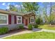 Inviting front entrance with a covered porch, red door, and well-maintained landscaping with mature trees at 1725 Bristol Rd, Statesville, NC 28677