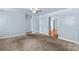 Spacious living room with neutral carpet, soft blue walls and view of interior doorways at 1725 Bristol Rd, Statesville, NC 28677