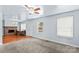 Bright living room featuring neutral carpet, ceiling fan, and a fireplace that adds a cozy focal point at 1725 Bristol Rd, Statesville, NC 28677