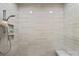 Modern walk-in shower featuring linear tiled walls, a built-in shelf, and a rain shower head at 19329 Watermark Dr # 531, Cornelius, NC 28031