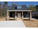 Charming home features a welcoming front porch with brick pillars and a well-manicured lawn at 202 Westerwood Dr, Rock Hill, SC 29732