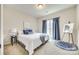 A cozy bedroom features a painting on an easel, soft carpet, and a comfortable bed at 2023 Aragon Ln, Gastonia, NC 28056