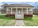 Charming home featuring a quaint front porch with brick foundation and a well-maintained lawn at 203 Jackson St, Fort Mill, SC 29715