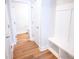 Hallway with coat rack, hardwood flooring, and entrance to half bathroom at 219 Halemarg Dr, Belmont, NC 28012