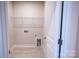Bright laundry room with tile floor, door to right and shelving on the wall at 219 Halemarg Dr, Belmont, NC 28012