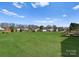 Expansive green backyard featuring outbuildings with neighborhood view in the distance at 238 Lippard Springs Cir, Statesville, NC 28677