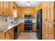 Functional kitchen featuring wooden cabinets, granite countertops, black appliances, and tiled backsplash at 238 Lippard Springs Cir, Statesville, NC 28677