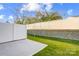 Backyard featuring a privacy fence, patio, and retaining wall with green grass at 2385 Hedgecliff Rd, Kannapolis, NC 28025