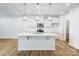 Bright kitchen boasts a large island, stainless appliances, pendant lighting, and sleek white cabinetry at 2385 Hedgecliff Rd, Kannapolis, NC 28025