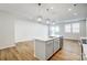 Open kitchen features island, stainless steel dishwasher and stove, light countertops, and view to living area at 2385 Hedgecliff Rd, Kannapolis, NC 28025