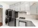 Kitchen with gray cabinets, black appliances, countertop and stacked washer/dryer at 306 Nance Rd, Charlotte, NC 28214
