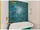 Close-up of a green standalone tub in a bathroom with blue backsplash and gold fixtures at 311 W Center Ave, Mooresville, NC 28115