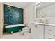 A bathroom with a green tub and shower showcasing blue hexagon backsplash tile at 311 W Center Ave, Mooresville, NC 28115
