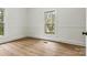 Bright bedroom featuring wood-look flooring, two windows, and wainscotting at 311 W Center Ave, Mooresville, NC 28115