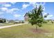 Two-story home on a corner lot with a well-manicured lawn and a young tree in the front yard at 4630 Bent Green Ln, Monroe, NC 28112