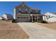 Two-story home featuring a two-car garage, covered front porch, and well-maintained landscaping against a clear blue sky at 4630 Bent Green Ln, Monroe, NC 28112