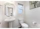 Bright powder room featuring pedestal sink, toilet, and decorative mirror at 4630 Bent Green Ln, Monroe, NC 28112