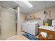 Functional laundry room with a shower, washer, dryer, utility sink, and storage shelves at 4875 Sulpher Springs Ne Rd, Hickory, NC 28601