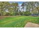 Green backyard with a wood fence and mature trees offers privacy and space for activities at 500 Lansdowne Rd, Charlotte, NC 28270