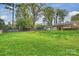 Large, grassy backyard featuring mature trees and a trampoline at 500 Lansdowne Rd, Charlotte, NC 28270
