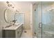 Elegant bathroom featuring dual vanities, a glass block window, and a frameless glass shower at 500 Lansdowne Rd, Charlotte, NC 28270
