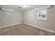 Unfurnished bedroom with neutral carpet, trim and paint and two windows at 500 Lansdowne Rd, Charlotte, NC 28270
