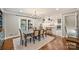 Open dining area with modern lighting and a view of the updated kitchen and outdoor patio at 500 Lansdowne Rd, Charlotte, NC 28270