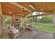 Relaxing screened porch with brick fireplace, ceiling fan, and comfortable seating area overlooking the yard at 500 Lansdowne Rd, Charlotte, NC 28270
