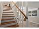 View of wood stairs with white risers and a wooden handrail leading to a carpeted room at 500 Lansdowne Rd, Charlotte, NC 28270