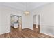 Bright dining room featuring hardwood floors and elegant lighting adjacent to an open-concept kitchen and additional space at 620 St Lukes Church Rd, Salisbury, NC 28146