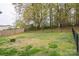 View of the large backyard with a partial wooden fence and a metal fire pit at 706 Annieline Dr, Shelby, NC 28152