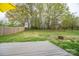 Expansive backyard showing a wooden deck with fire pit and greenery, framed by trees and fences at 706 Annieline Dr, Shelby, NC 28152