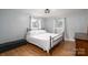 Serene bedroom with a metal bed frame, cozy bedding, and natural light from the windows at 706 Annieline Dr, Shelby, NC 28152