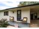 Cozy front porch featuring brick accents, comfortable wicker seating, and black painted door at 706 Annieline Dr, Shelby, NC 28152