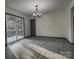 Bright living room with gray wood-look floors, slider to the deck, and decorative chandelier at 923 Wyke Rd, Shelby, NC 28150