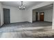 Open living room featuring light gray floors, a chandelier, contrasting doors, and seamless flow to other living spaces at 923 Wyke Rd, Shelby, NC 28150