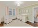 Charming Bedroom features a crib, light green walls, an area rug, a glider chair and pink curtains at 925 E 35Th St, Charlotte, NC 28205
