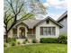 Charming cottage-style home with a well-maintained lawn and inviting front porch with beautiful flowers at 925 E 35Th St, Charlotte, NC 28205