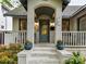 Inviting front porch with stylish door and potted plants, perfect for relaxing and enjoying the outdoors at 925 E 35Th St, Charlotte, NC 28205