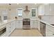 Bright kitchen featuring stainless steel appliances, white cabinets, and ample counter space with tiled backsplash at 925 E 35Th St, Charlotte, NC 28205