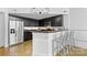 Kitchen with stainless steel appliances, dark cabinets and a counter bar with modern white stools at 925 Westmere Ave, Charlotte, NC 28208