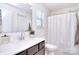 Bright bathroom with a white vanity, shower with curtain, and a large mirror at 966 Scotch Meadows Loop, Monroe, NC 28110