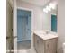 This bathroom features a vanity with white countertop, chrome hardware and a large mirror with modern lighting at 9842 Quercus Ln, Huntersville, NC 28078