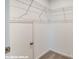 Walk-in closet with white walls, neutral carpeting, metal shelving, and a door for a private storage solution at 9842 Quercus Ln, Huntersville, NC 28078